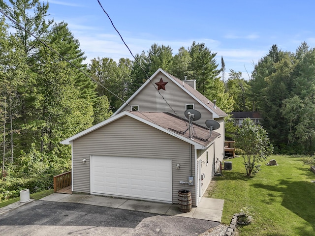 view of home's exterior featuring a garage, a lawn, a deck, and a shingled roof