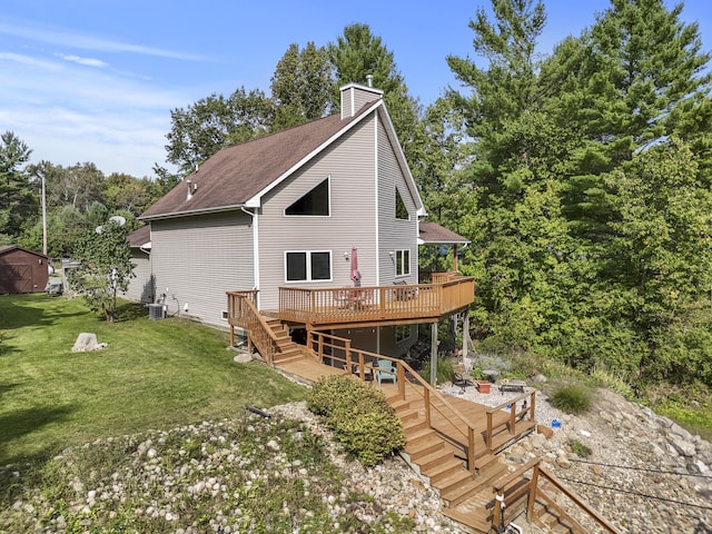 back of house featuring a wooden deck, stairs, roof with shingles, a lawn, and a chimney