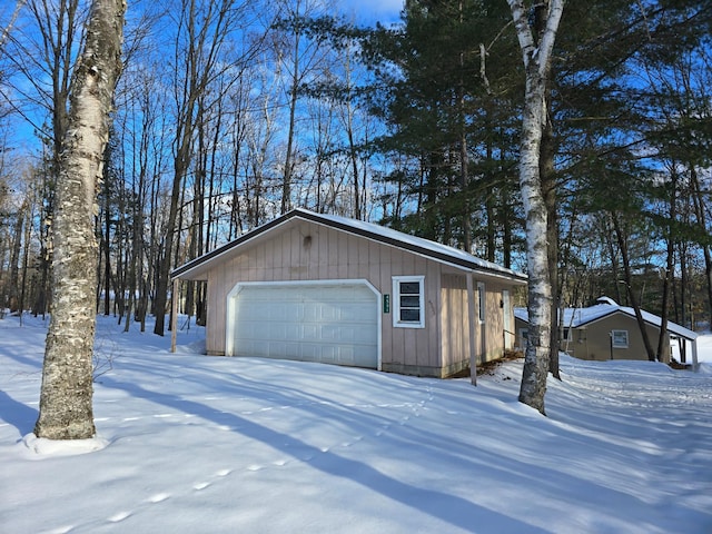 snow covered garage with a garage