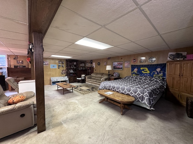 bedroom with wooden walls and a paneled ceiling