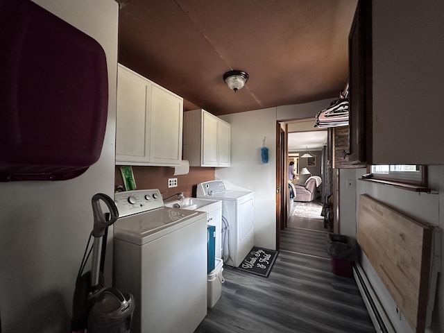 washroom featuring dark wood finished floors, cabinet space, and washer and clothes dryer