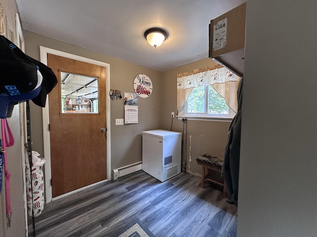 laundry area with a baseboard heating unit, dark wood finished floors, and laundry area