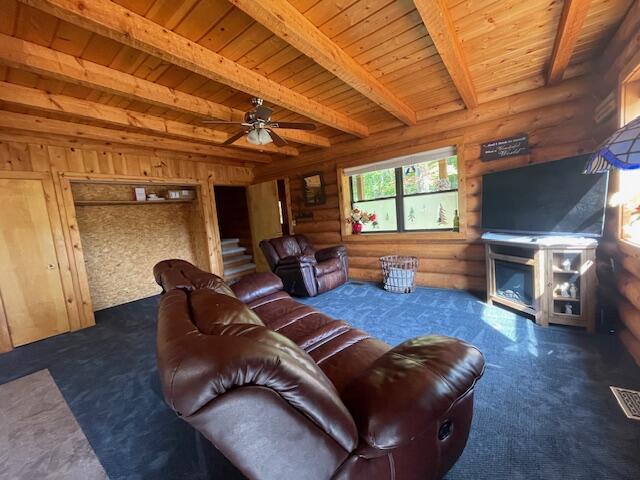 living area featuring carpet, beamed ceiling, wooden ceiling, a fireplace, and log walls