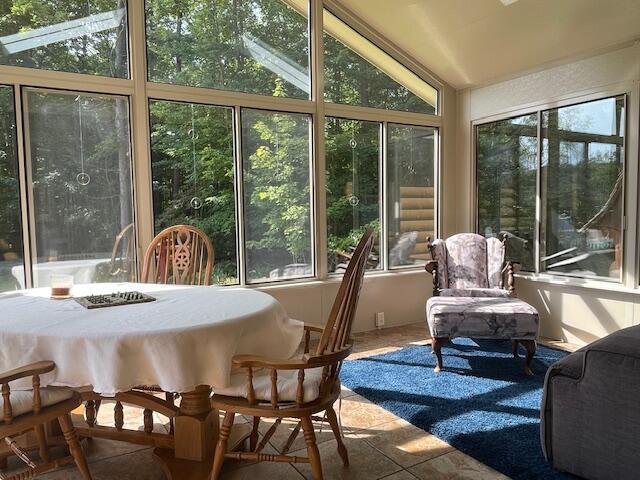 sunroom / solarium featuring lofted ceiling