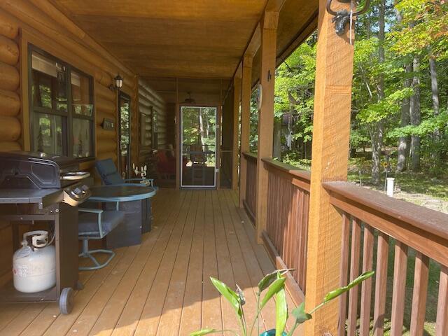 wooden terrace featuring area for grilling and covered porch