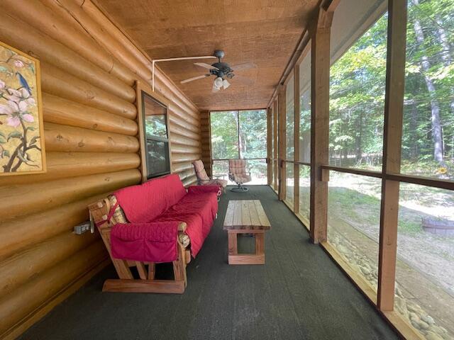 sunroom featuring ceiling fan and wooden ceiling