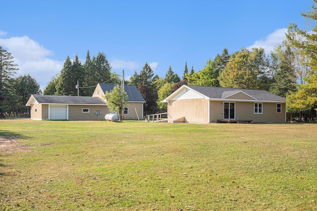 rear view of property featuring a yard and a garage