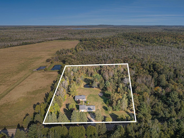 birds eye view of property featuring a view of trees and a rural view