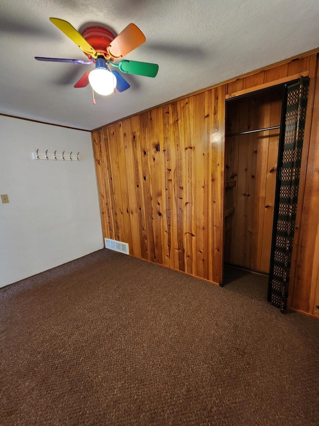 1130 Knollwood, Saint Helen, MI 48656 - unfurnished room featuring wooden walls, carpet, and a ceiling fan