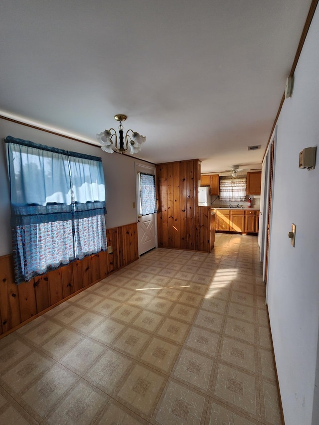 1130 Knollwood, Saint Helen, MI 48656 - spare room with wooden walls, light flooring, a chandelier, and a wainscoted wall