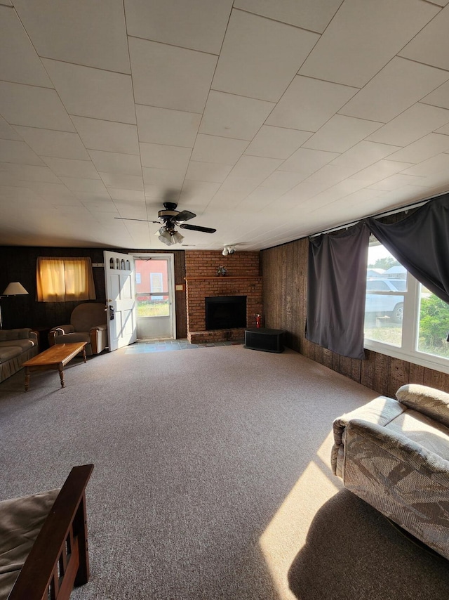1130 Knollwood, Saint Helen, MI 48656 - carpeted living room with wooden walls, a fireplace, and a ceiling fan