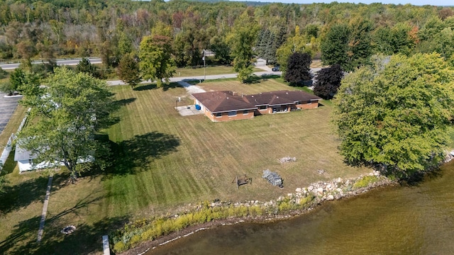 drone / aerial view featuring a forest view and a water view