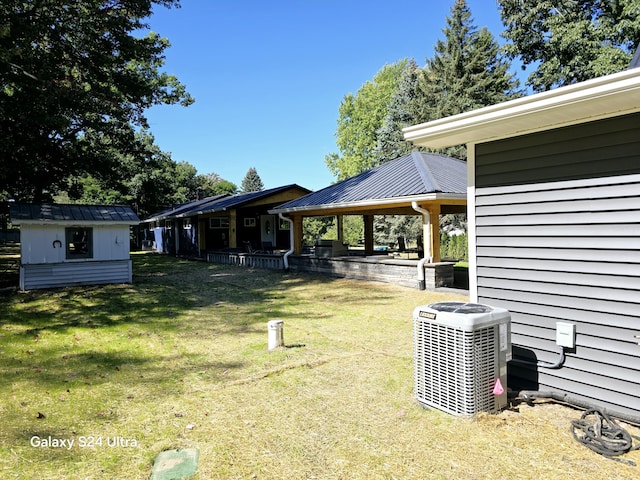 view of yard featuring a gazebo, central air condition unit, a shed, and an outdoor structure