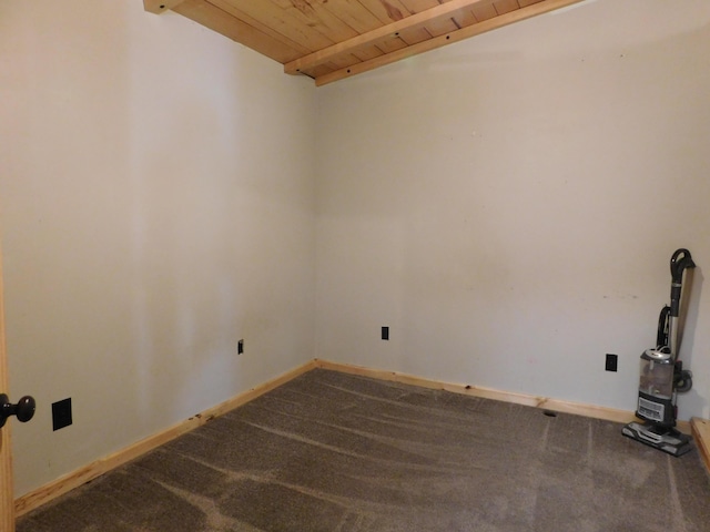 spare room featuring carpet flooring, beamed ceiling, wooden ceiling, and baseboards