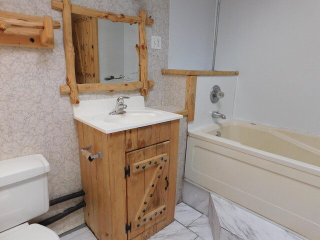 bathroom featuring vanity, wallpapered walls, a tub, toilet, and marble finish floor