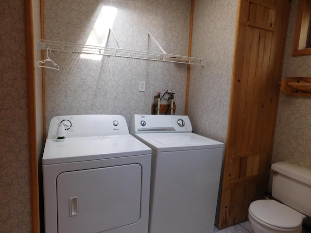 washroom featuring washer and clothes dryer, laundry area, and wallpapered walls