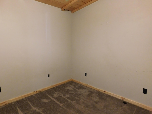 unfurnished room with beam ceiling, baseboards, wood ceiling, and dark carpet