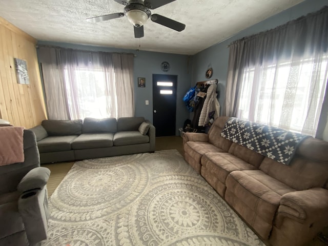 living room with a textured ceiling and ceiling fan