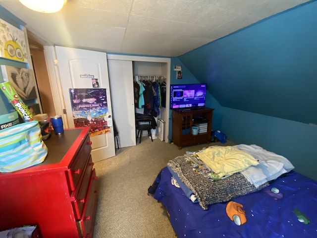 carpeted bedroom featuring a closet and vaulted ceiling