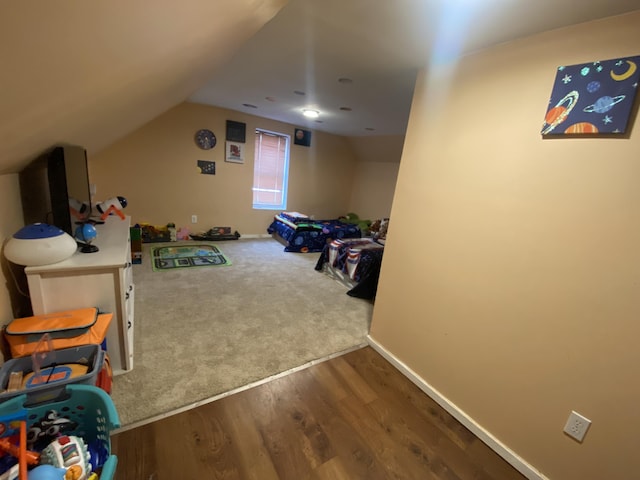 playroom featuring carpet, lofted ceiling, wood finished floors, and baseboards