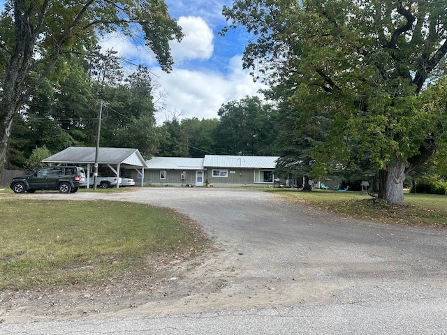 ranch-style home featuring a front yard and dirt driveway