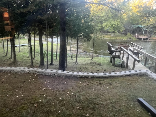 view of yard featuring a boat dock and a water view