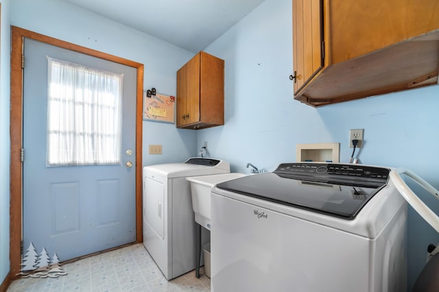 laundry area featuring washing machine and dryer, cabinet space, and light floors