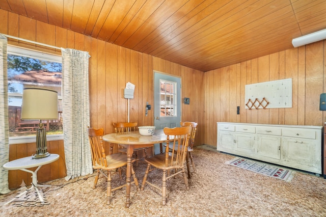 dining space featuring wood walls and wooden ceiling