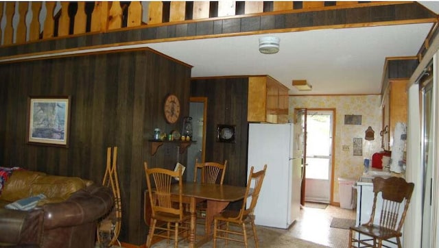 dining area featuring wood walls, wallpapered walls, and crown molding