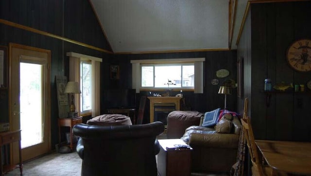 living area with a healthy amount of sunlight, a fireplace, light colored carpet, and lofted ceiling