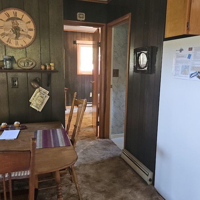 dining space with a baseboard heating unit and carpet