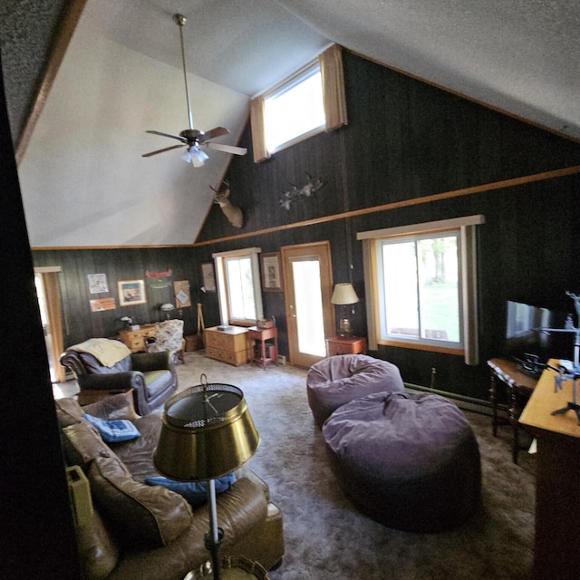 living room with high vaulted ceiling, carpet floors, wooden walls, and a ceiling fan