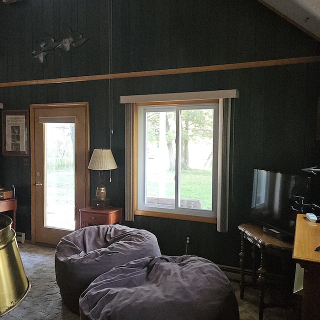 carpeted living area featuring plenty of natural light and vaulted ceiling