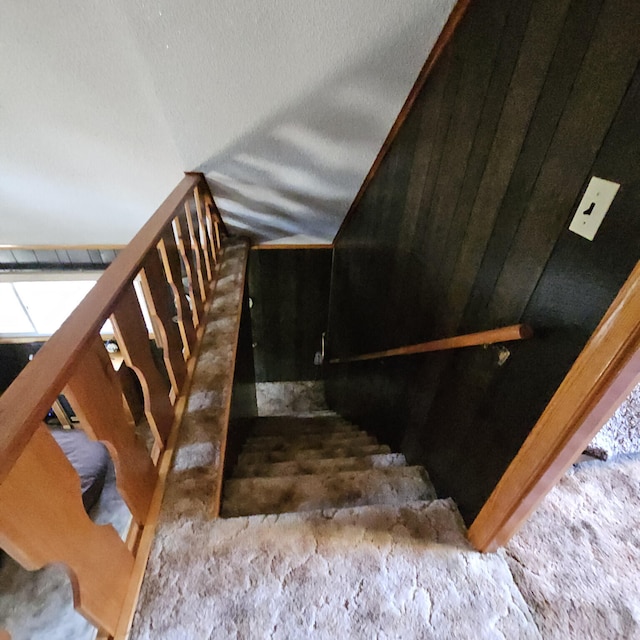 stairs with lofted ceiling and a textured ceiling