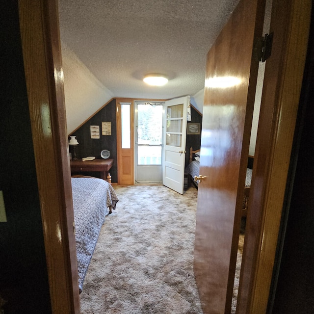 bedroom with a textured ceiling, lofted ceiling, and carpet