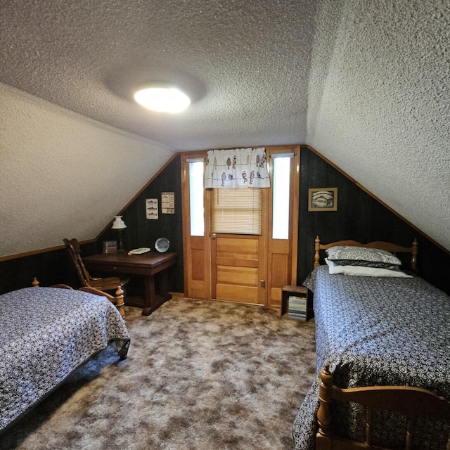 bedroom featuring vaulted ceiling, carpet flooring, and a textured ceiling