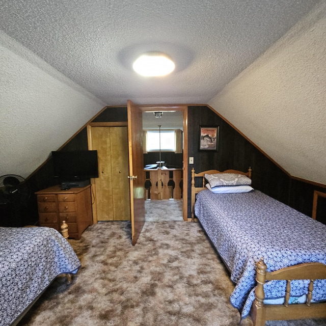 carpeted bedroom featuring a textured ceiling and vaulted ceiling