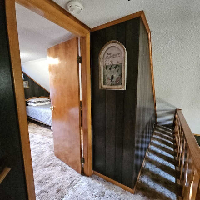 interior space with stairs, vaulted ceiling, carpet floors, and a textured ceiling