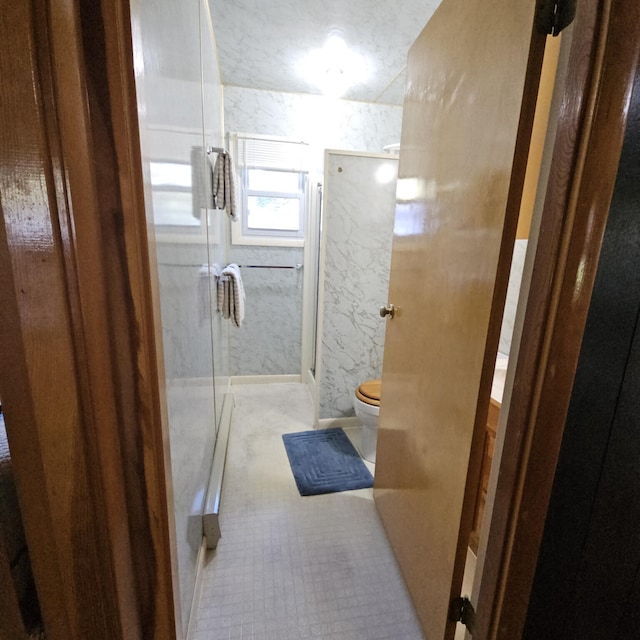 full bath featuring a stall shower and toilet