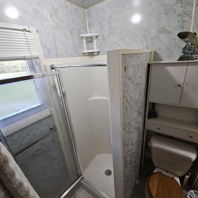 bathroom with a stall shower and toilet