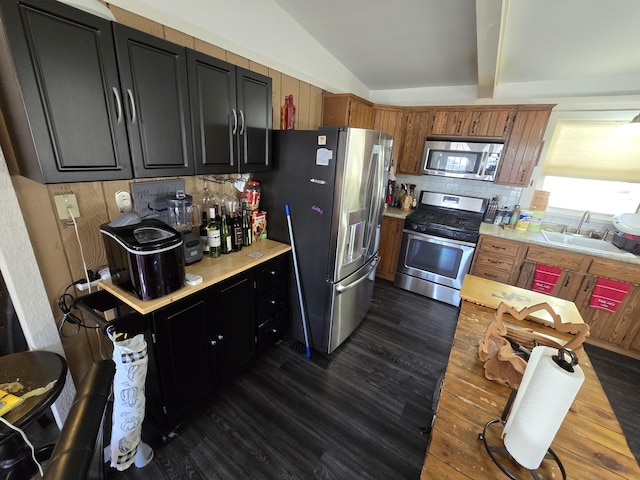 kitchen with a sink, stainless steel appliances, dark wood-style flooring, and light countertops