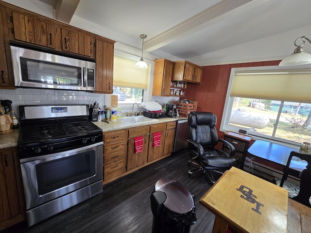 kitchen featuring a sink, tasteful backsplash, dark wood finished floors, stainless steel appliances, and light countertops