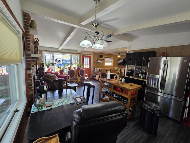 dining space with lofted ceiling with beams, dark wood finished floors, and ceiling fan with notable chandelier