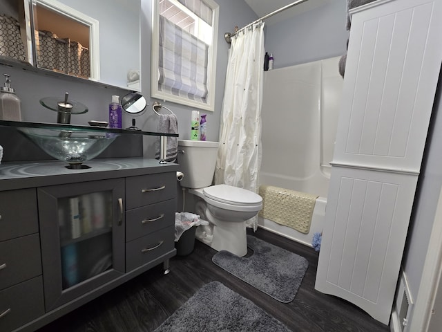 bathroom featuring shower / bath combination with curtain, toilet, vanity, and wood finished floors