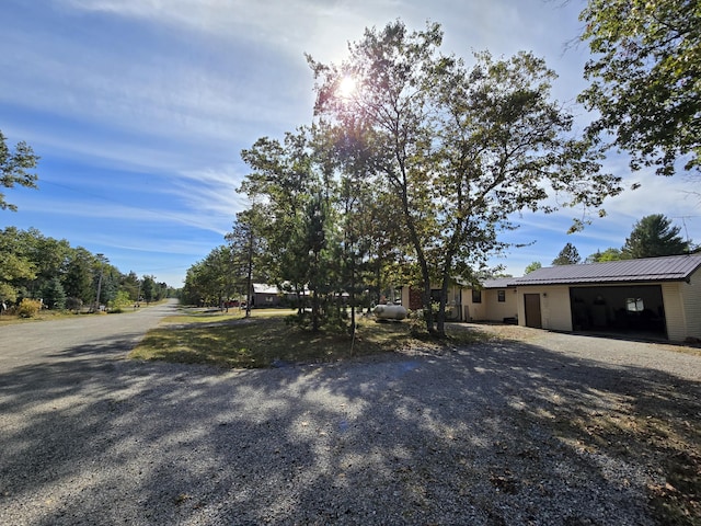 view of front of house with metal roof, gravel driveway, and an attached garage