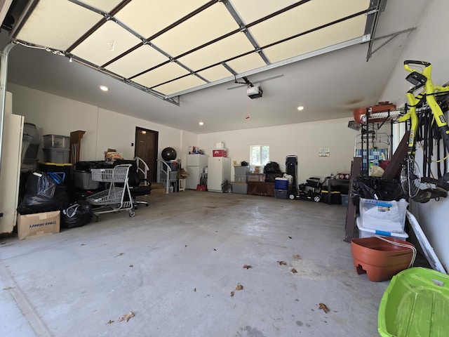 garage featuring a garage door opener and freestanding refrigerator