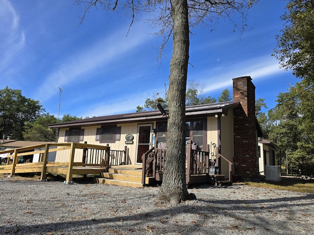 view of front of home with a chimney and a wooden deck