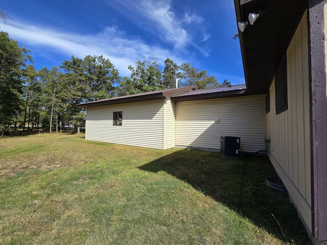 exterior space featuring central air condition unit, a yard, and metal roof