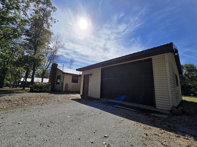 exterior space with an outbuilding, metal roof, and a garage