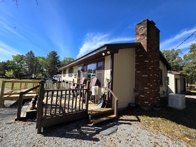 view of side of property with a wooden deck and a chimney